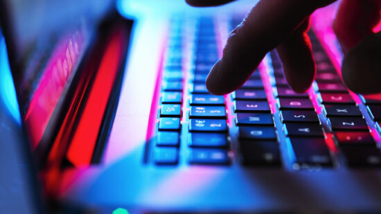 GettyImages-1175885065_typing at his laptop computer at night